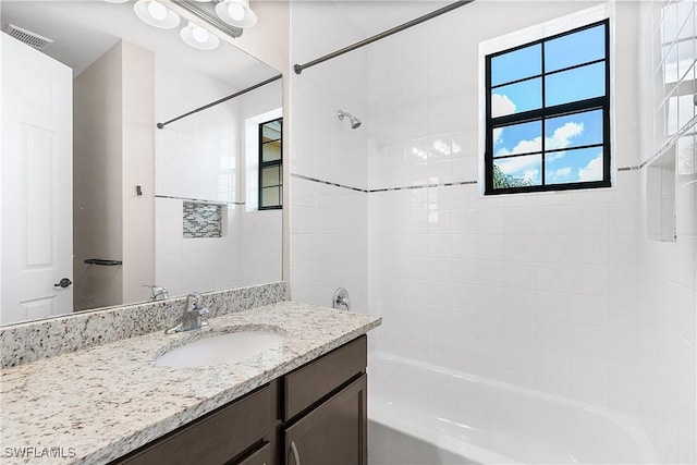 bathroom with vanity and tiled shower / bath combo