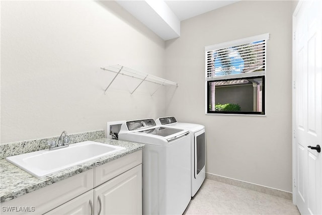 clothes washing area featuring cabinets, independent washer and dryer, and sink