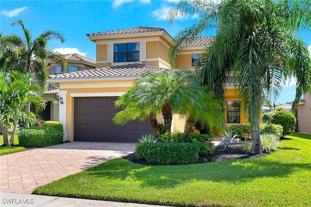 mediterranean / spanish house featuring a front yard and a garage