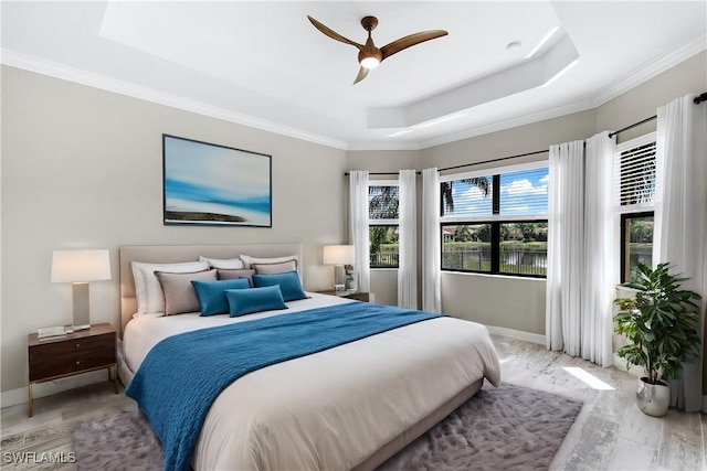 bedroom with a raised ceiling, ceiling fan, and ornamental molding