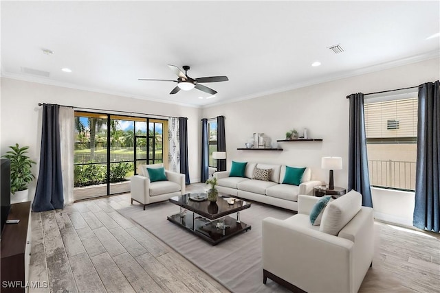 living room with crown molding, light hardwood / wood-style flooring, and ceiling fan