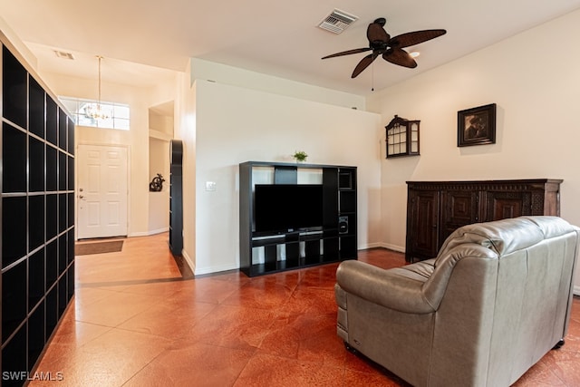 living room featuring ceiling fan with notable chandelier