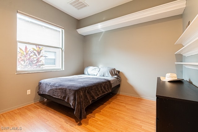 bedroom with multiple windows and light hardwood / wood-style floors