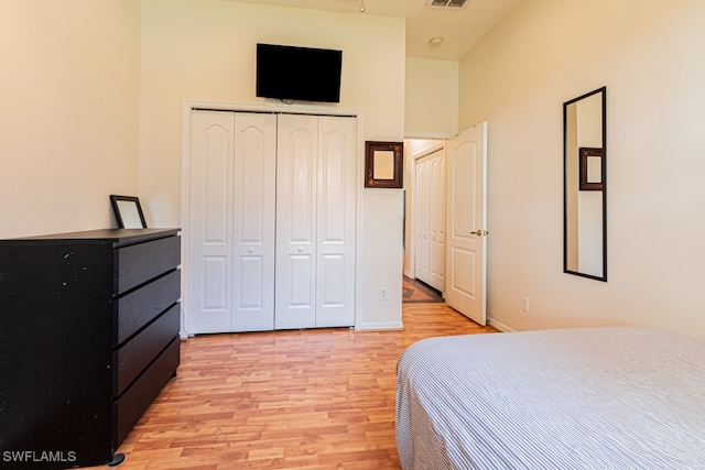 bedroom with light wood-type flooring and a closet