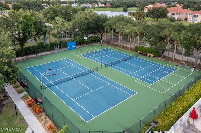 view of tennis court with a water view