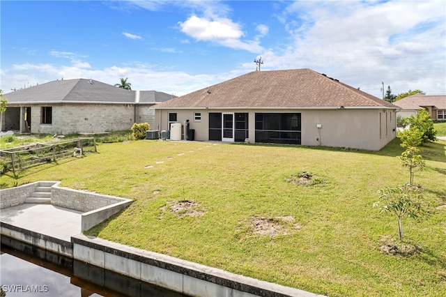 back of house featuring a yard and a sunroom