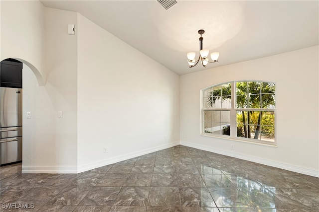 unfurnished room featuring a notable chandelier