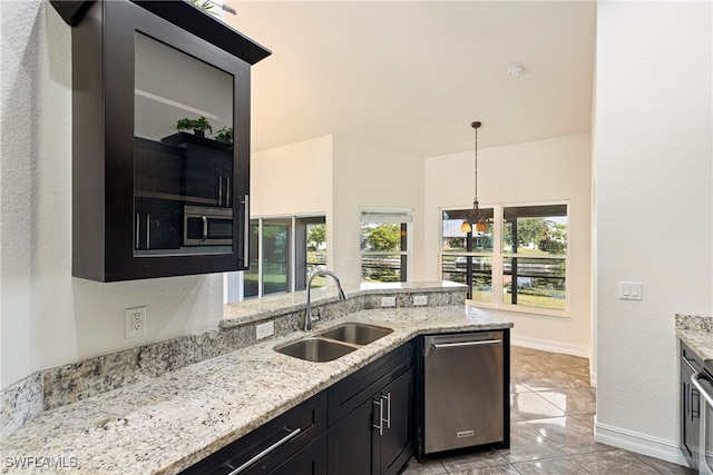 kitchen with sink, decorative light fixtures, light stone counters, stainless steel appliances, and a chandelier