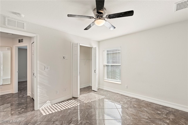 unfurnished bedroom with ceiling fan and a closet