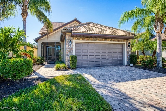 10911 Glenhurst St, Fort Myers, FL 33913 - view of front facade featuring stone siding, stucco siding, decorative driveway, a sunroom, and a garage