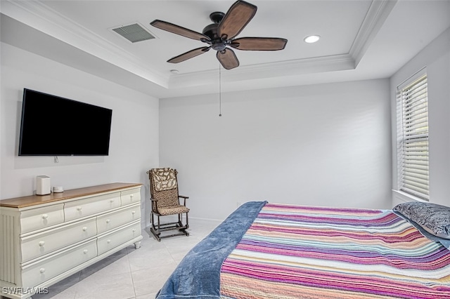 tiled bedroom with ceiling fan, a raised ceiling, and ornamental molding