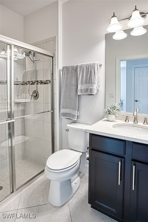 bathroom with tile patterned flooring, vanity, toilet, and walk in shower