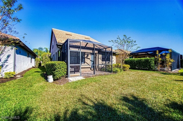 back of property featuring a lanai and a lawn