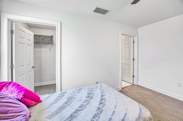 carpeted bedroom featuring ceiling fan and a closet