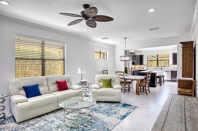 tiled living room with ceiling fan and ornamental molding