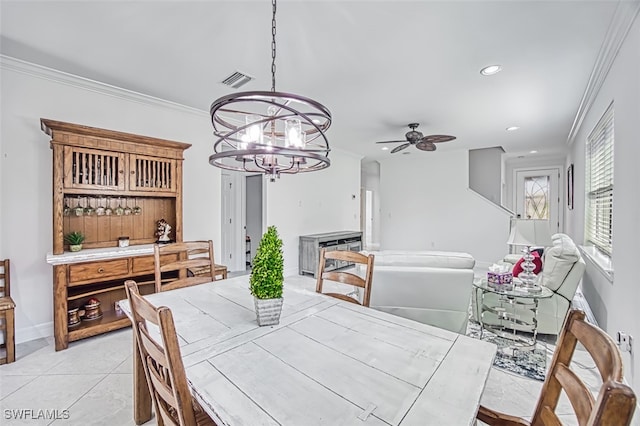 tiled dining space with ceiling fan with notable chandelier and crown molding