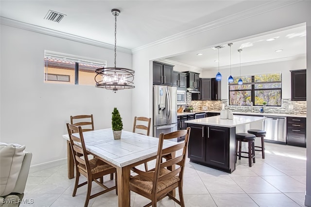 tiled dining room featuring a notable chandelier and ornamental molding