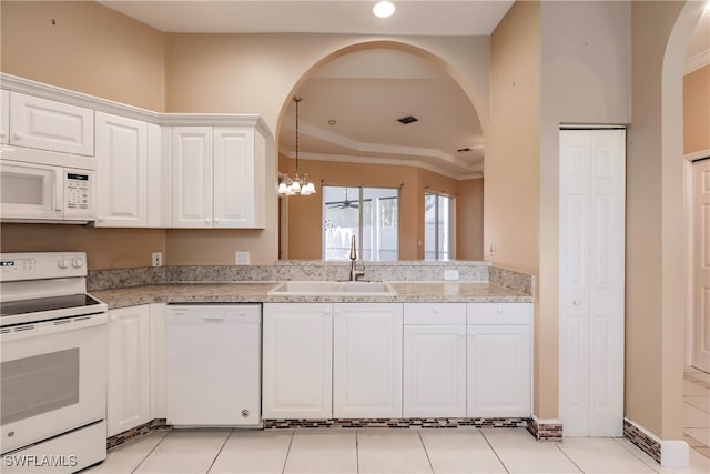 kitchen with white cabinets, light tile patterned flooring, sink, white appliances, and an inviting chandelier