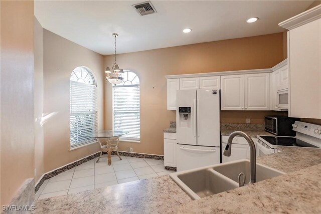 kitchen with white cabinets, light tile patterned flooring, sink, white appliances, and a notable chandelier