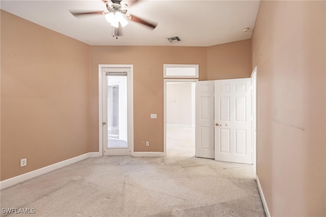 interior space with ceiling fan and light colored carpet