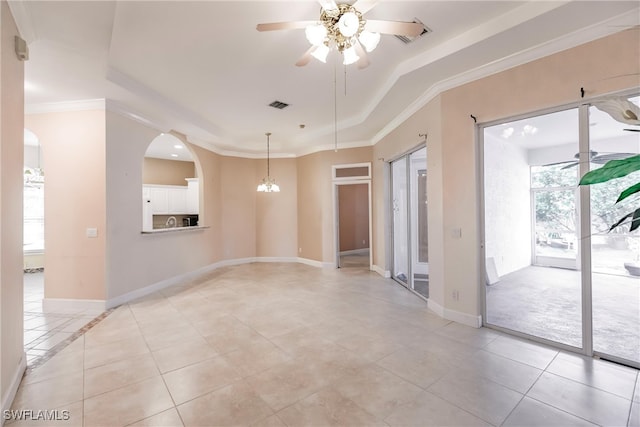 tiled empty room featuring ornamental molding, a tray ceiling, and ceiling fan