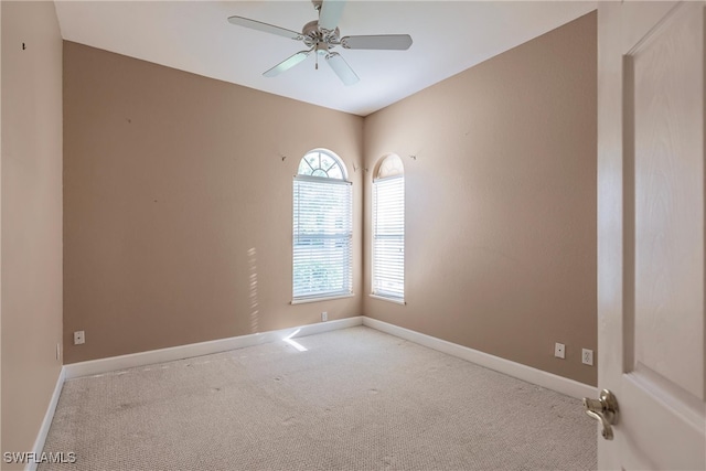 carpeted spare room with ceiling fan