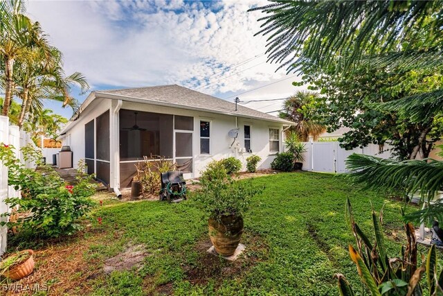 rear view of property with a yard and a sunroom