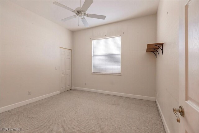 empty room featuring ceiling fan and light colored carpet