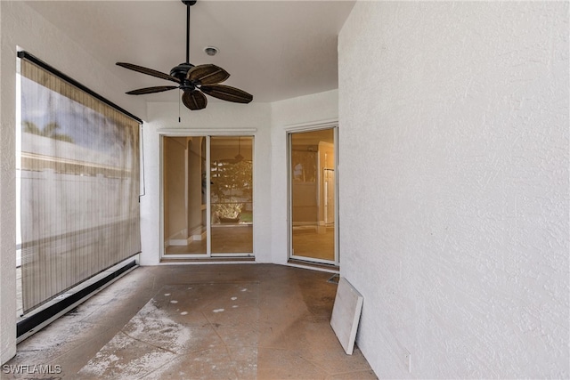 unfurnished sunroom featuring ceiling fan