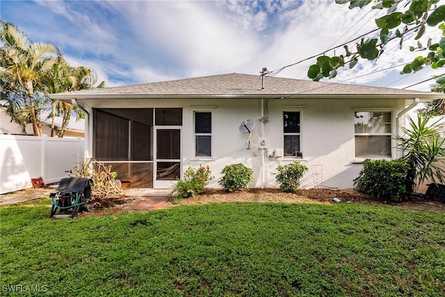 back of property featuring a sunroom and a yard