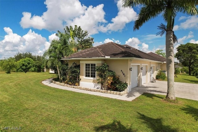 back of property with a garage and a lawn