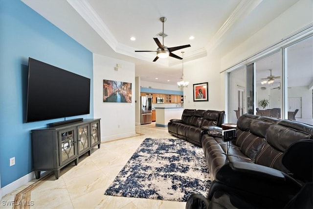 living room with a notable chandelier, ornamental molding, and a raised ceiling