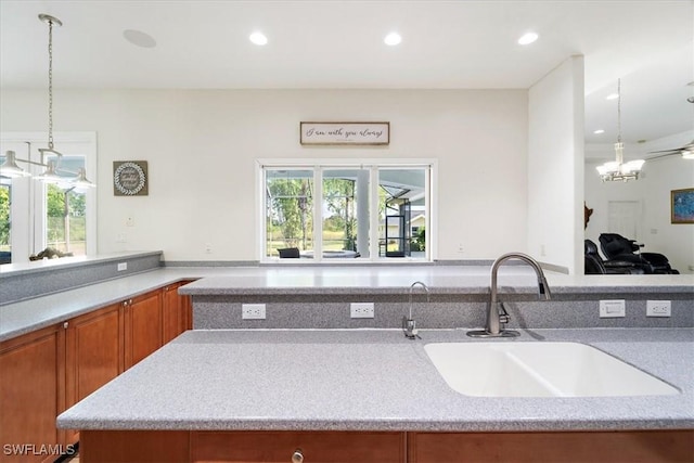 kitchen featuring pendant lighting, sink, and a notable chandelier