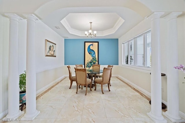 dining space featuring an inviting chandelier, a tray ceiling, and ornamental molding