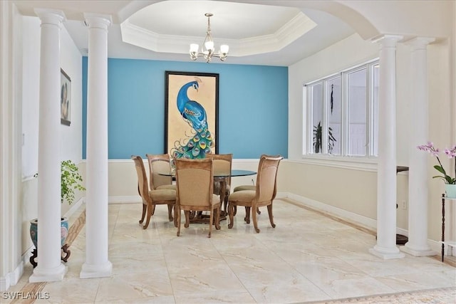 dining space featuring a raised ceiling, ornamental molding, and a notable chandelier