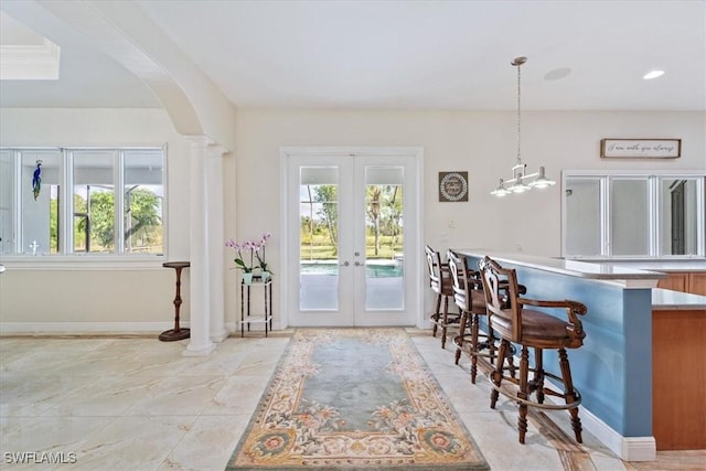 kitchen with french doors, a kitchen bar, and hanging light fixtures