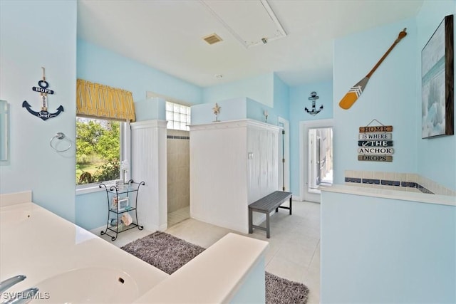 bathroom featuring sink, a tile shower, and tile patterned floors