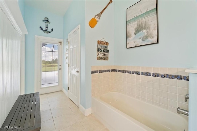 bathroom with a tub to relax in and tile patterned floors