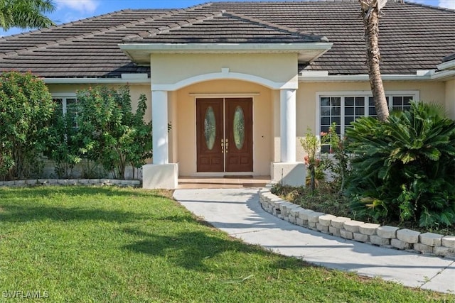 view of exterior entry with a lawn