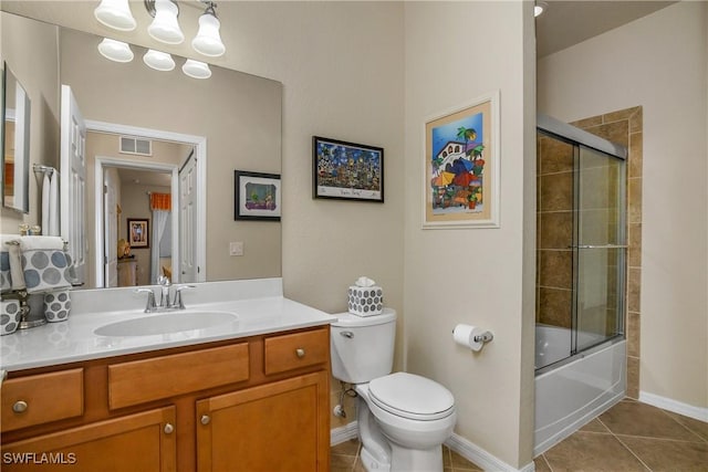 full bathroom featuring shower / bath combination with glass door, tile patterned flooring, vanity, and toilet