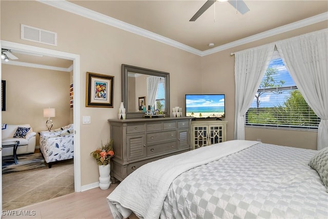 bedroom featuring ceiling fan, light hardwood / wood-style floors, and crown molding