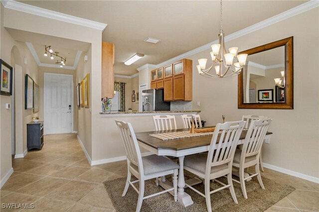 tiled dining area with crown molding and a chandelier