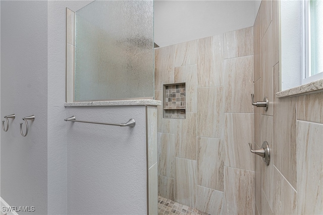 bathroom with tiled shower