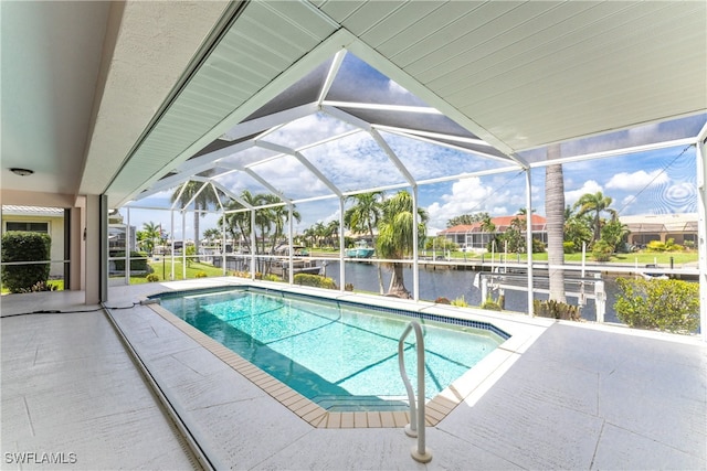 view of swimming pool featuring glass enclosure, a water view, and a patio