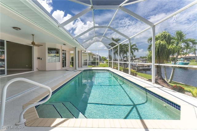 view of swimming pool with glass enclosure, ceiling fan, and a patio