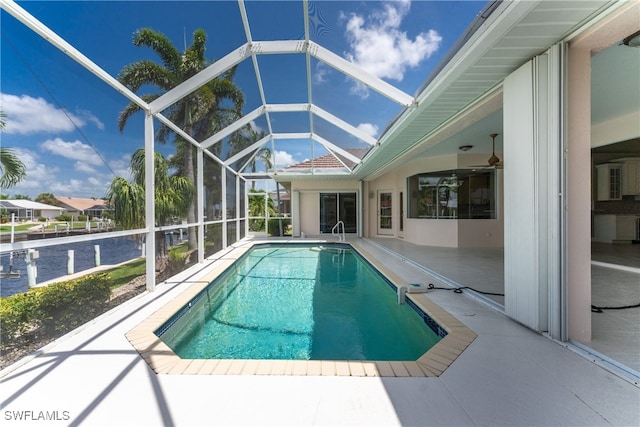 view of pool with glass enclosure, ceiling fan, and a patio area