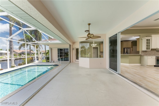 view of pool featuring ceiling fan, a lanai, a water view, and a patio area