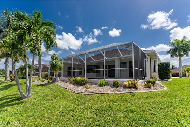 back of property with a lawn and glass enclosure