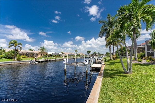 dock area featuring a lawn, a water view, and a lanai