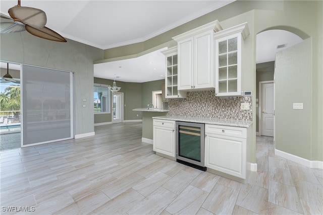 kitchen featuring decorative backsplash, wine cooler, ceiling fan, and white cabinetry